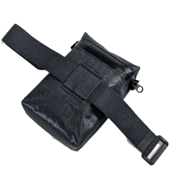 Side view of a compact bike saddle bag with Velcro attachment system for secure mounting.