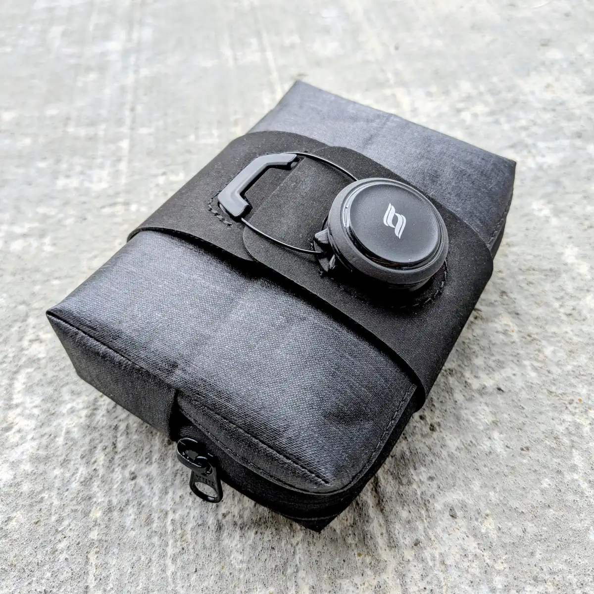 Small bike saddle bag with BOA-style rotary tightening system and low-profile compact design.